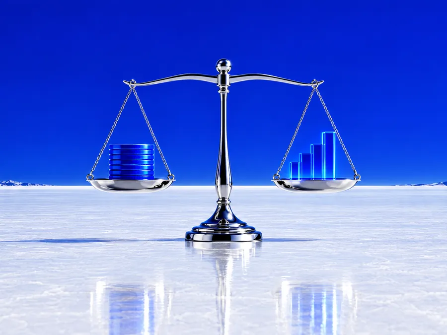 Chrome balance scale weighing blue coins on a white plain